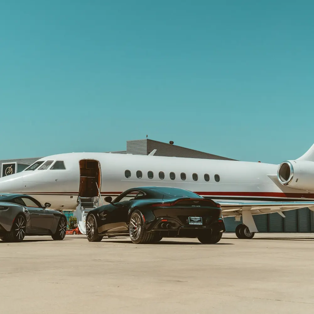 Large cabin Falcon jet on a ramp beside parked cars