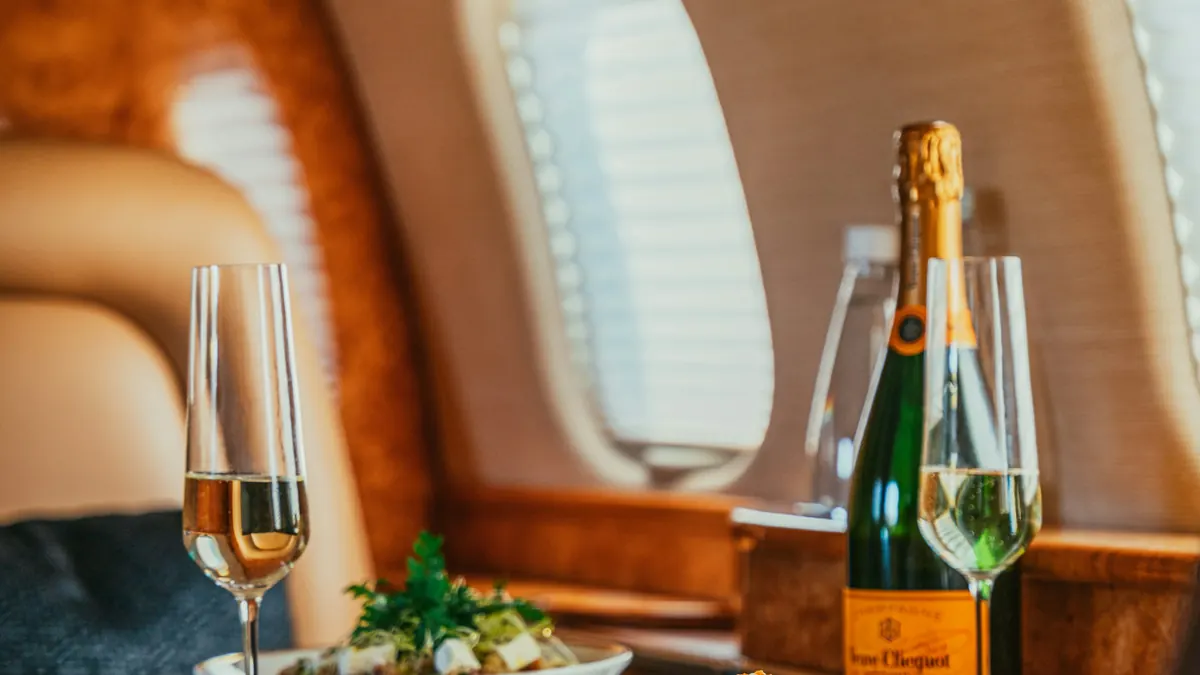 Champagne and a plated lunch by the window of a private jet
