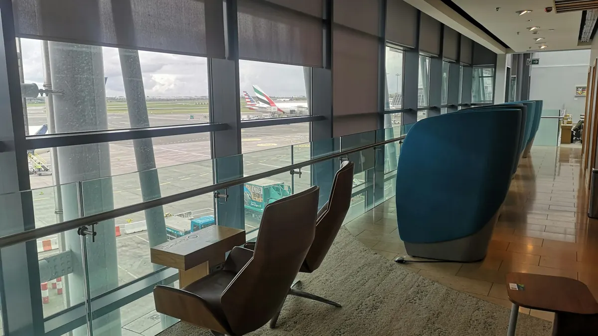 Airport lounge with tall windows overlooking parked aircraft