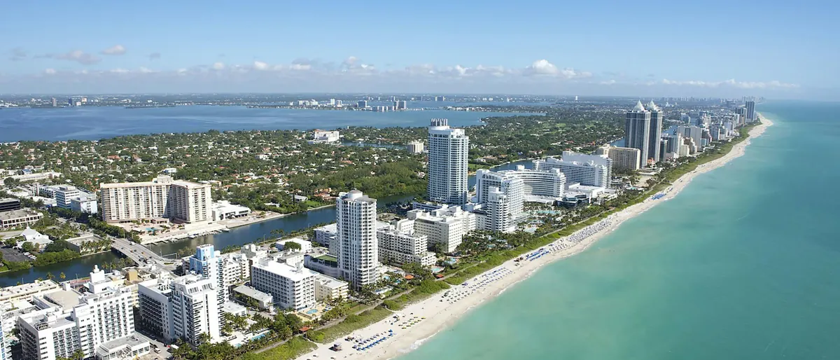 Aerial view of Miami Beach high-rises along a turquoise shoreline